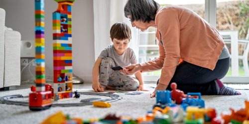 child-2022-03-04-17-19-14-utc GENEVA, SWITZERLAND - MARCH 23, 2020: Little toddler boy playing with grandmother with Lego bricks at home at quarantine isolation period during coronavirus pandemic. Family leisure activity and communication.