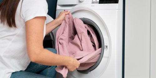 woman-taking-clothes-from-washing-machine woman-taking-clothes-from-washing-machine